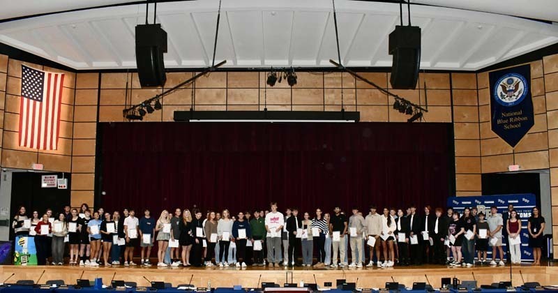 Student group photo on auditurium stage.