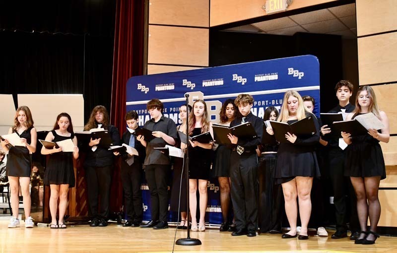 Student chorus performing on stage.
