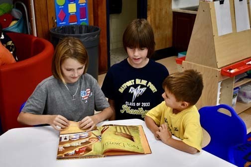 Students writing at table.