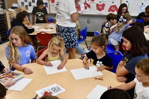 Students writing at table.