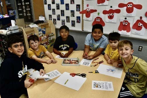Students writing at table.