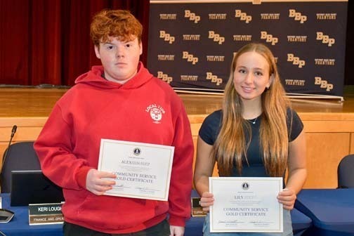 Two students holding certificates.
