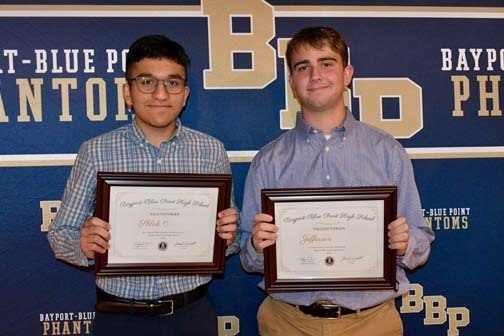 Two students holding certificates.