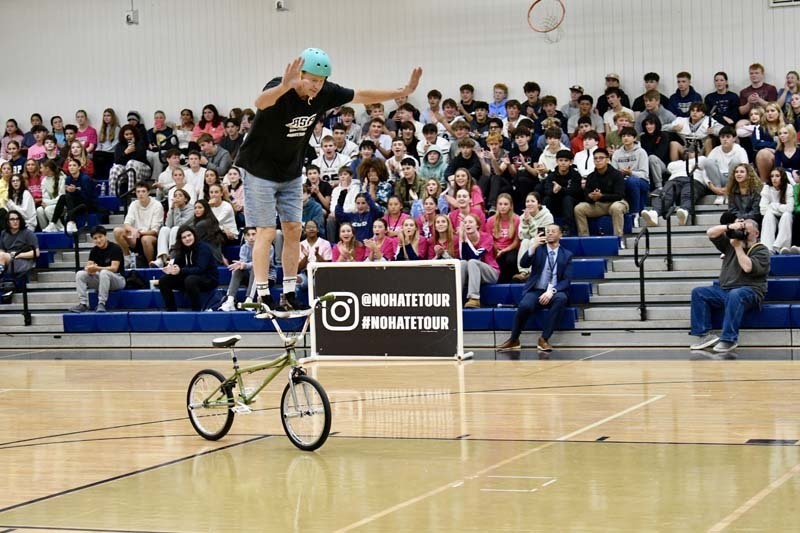 BMX professional doing tricks in gymnasium.