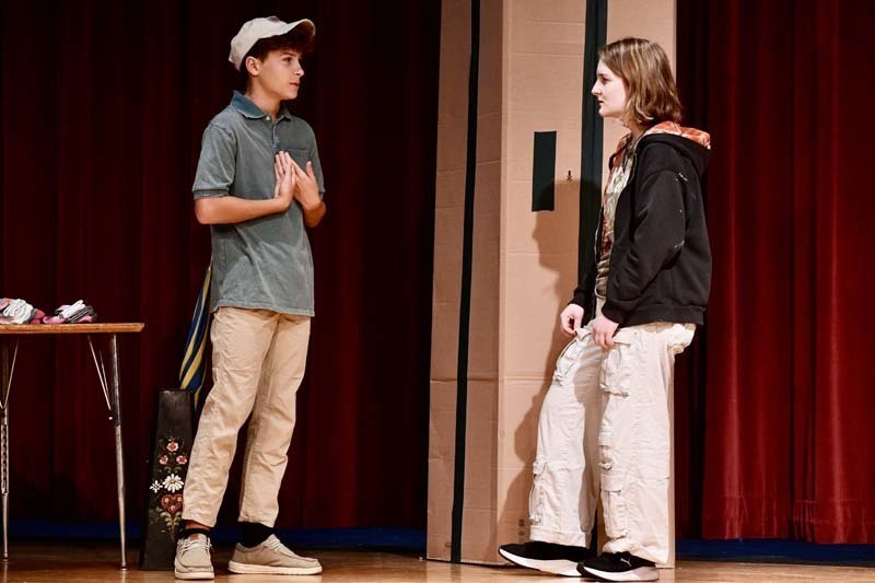 Students performing play on stage.