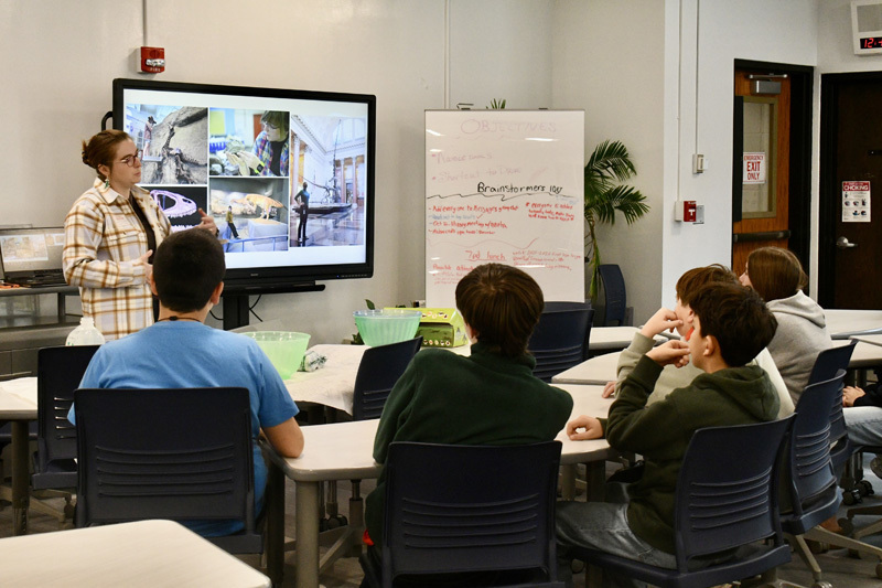 A group of children gathered around a table, focused on a science project