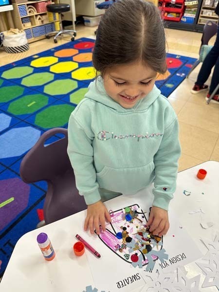 Student smiling while making art.