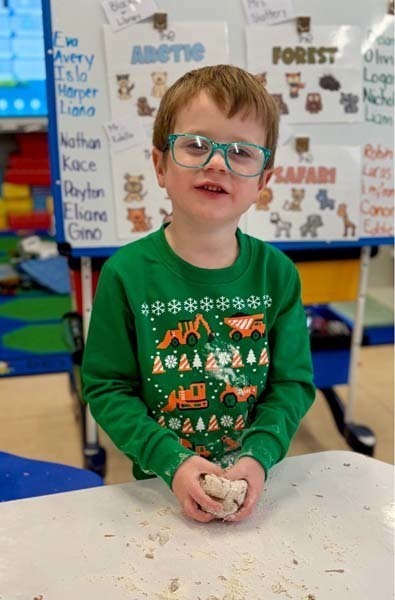 Student smiling while making art.