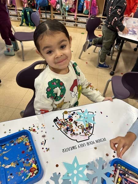 Student smiling while making art.