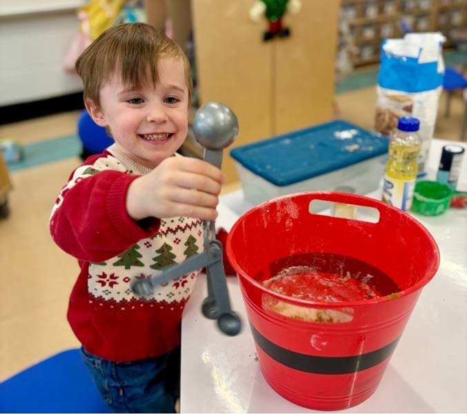 Student smiling while making art.