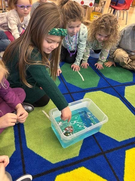 Studentssitting on rug.