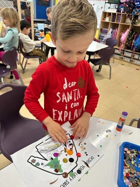Student smiling while making art.