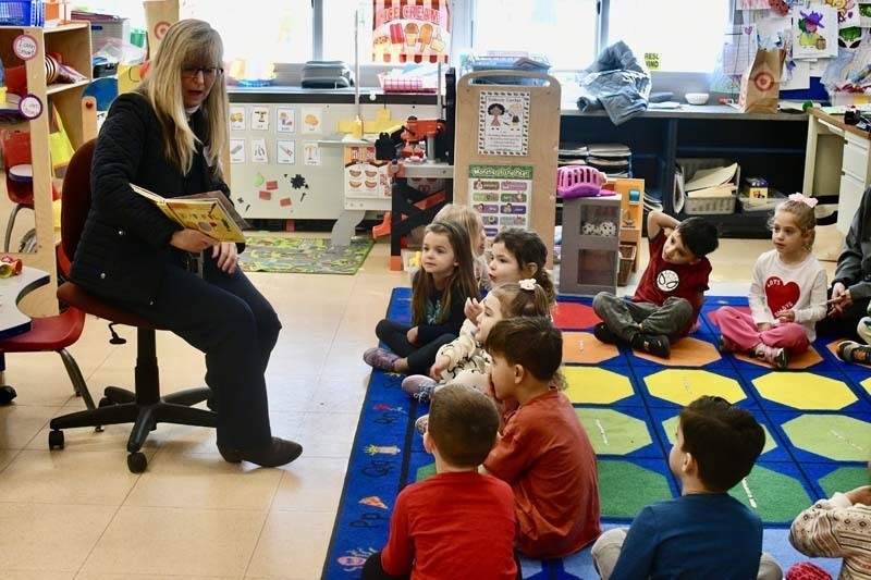 Students listening to older guest speak.