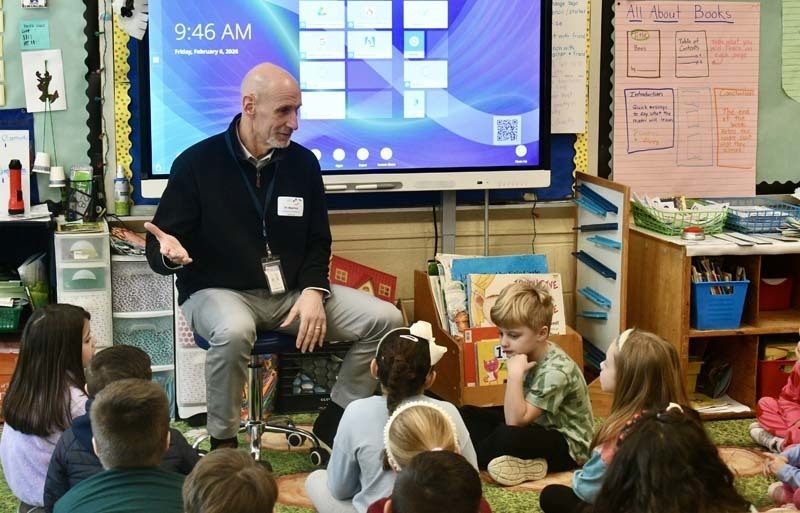 Students listening to older guest speak.