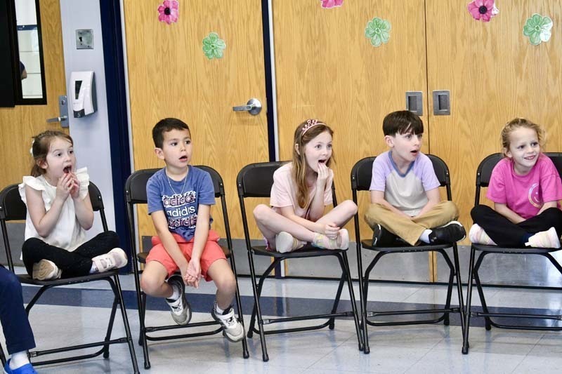 Students looking at snake being held by instructor.