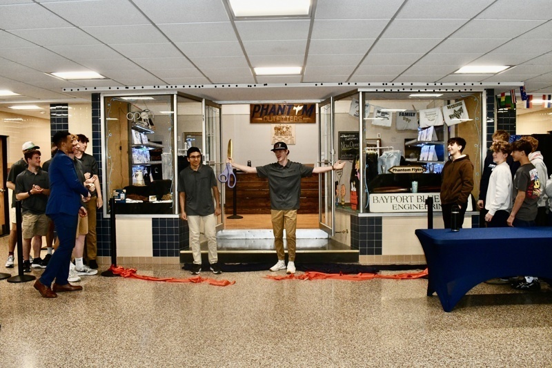 Interior view of Long Island Sign Designs showcasing a variety of custom apparel, including hoodies and printed designs, along with promotional pricing.