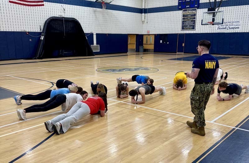Students doing push-ups in gymnasium.