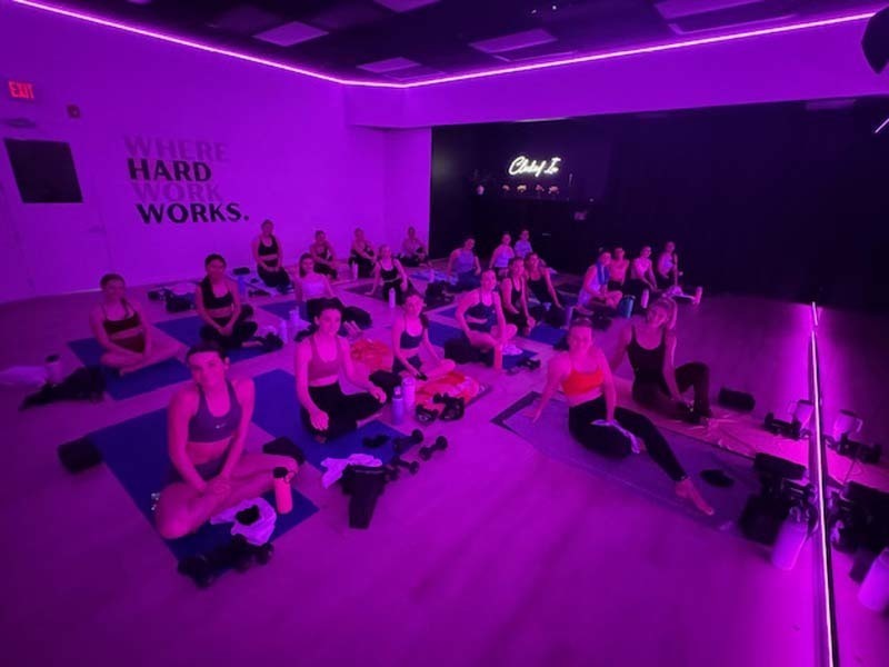 Students doing yoga in purple room.