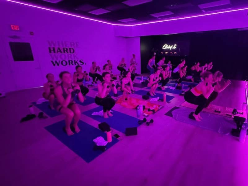 Students doing yoga in purple room.