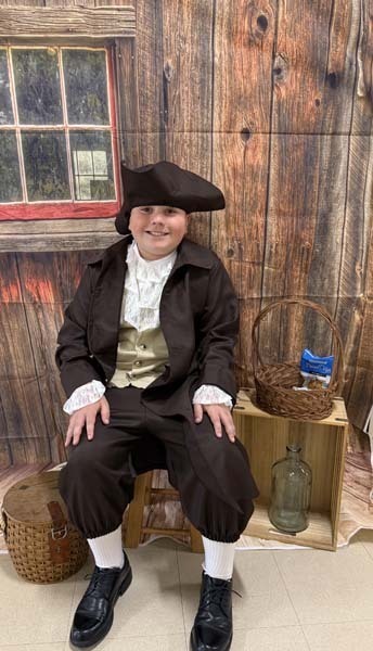 Students smiling, dressed in 1700s costumes.
