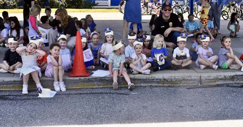 Students watching from sidewalk.