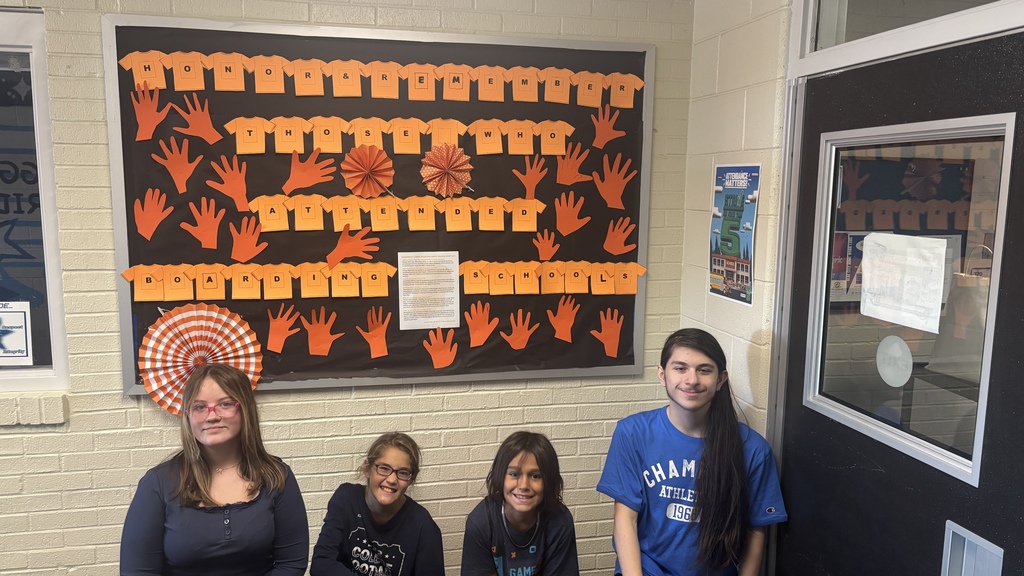 Photo of students and the bulletin board they created for Orange Shirt Day!