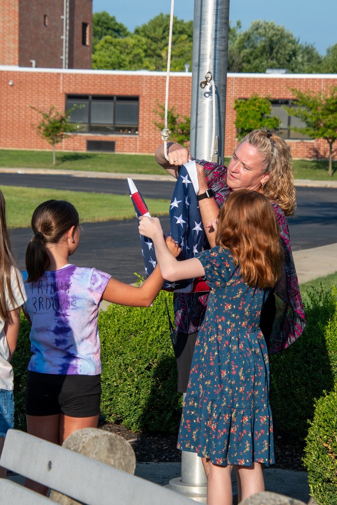 Mrs. Peveler showing kids how to raise the flag at Shaw Elementary