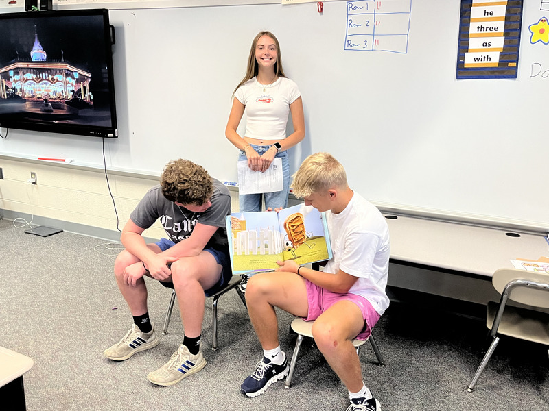 Gabe Taylor, Emma Brown, and Grey Livengood reading ot students.