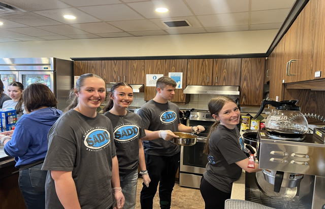 SADD students standing in front of oven with food
