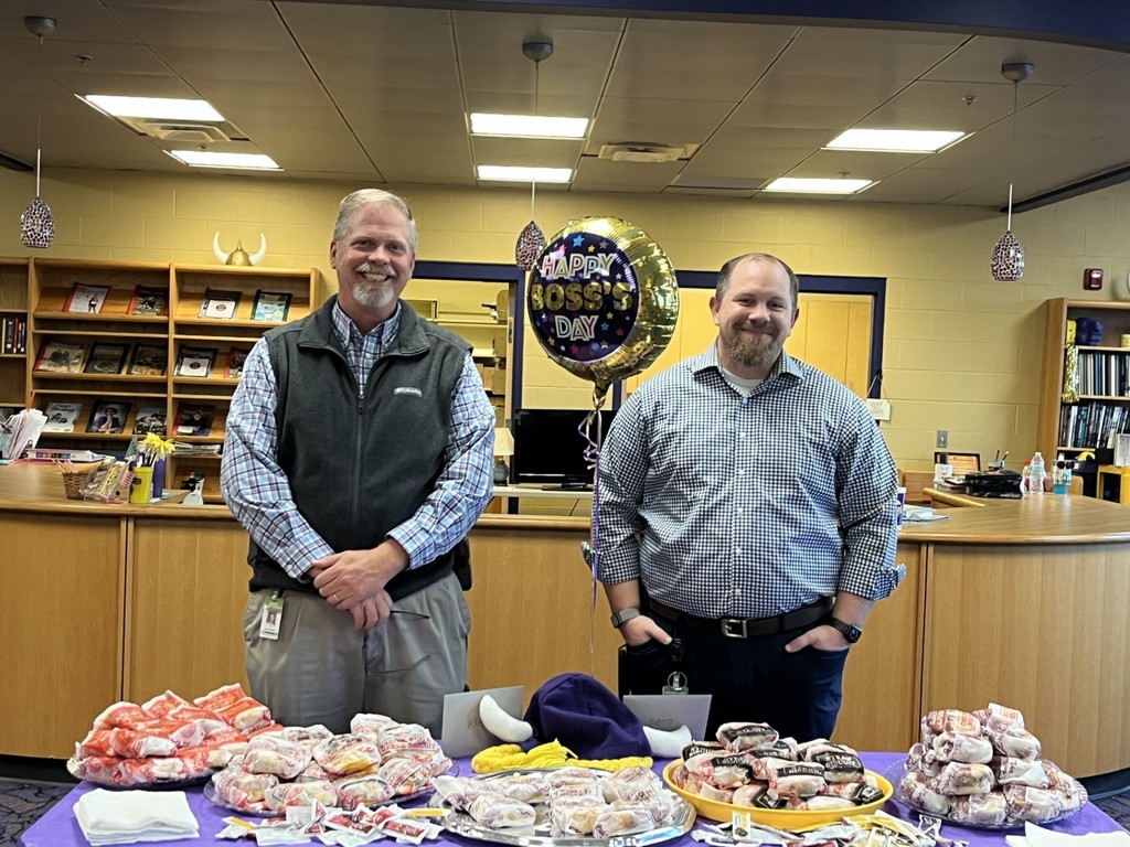 Men standing in front of breakfast food