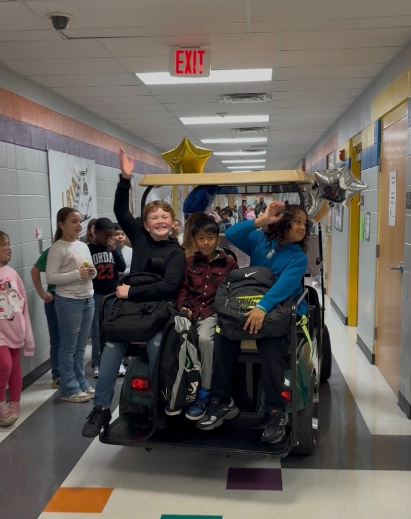 principals list riding a golf cart