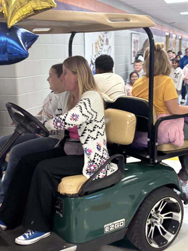 principals list riding a golf cart