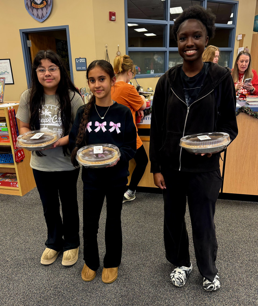 Three students with the pies they won.