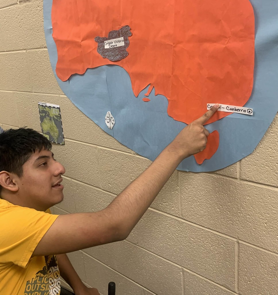 Student pointing to a location on a map