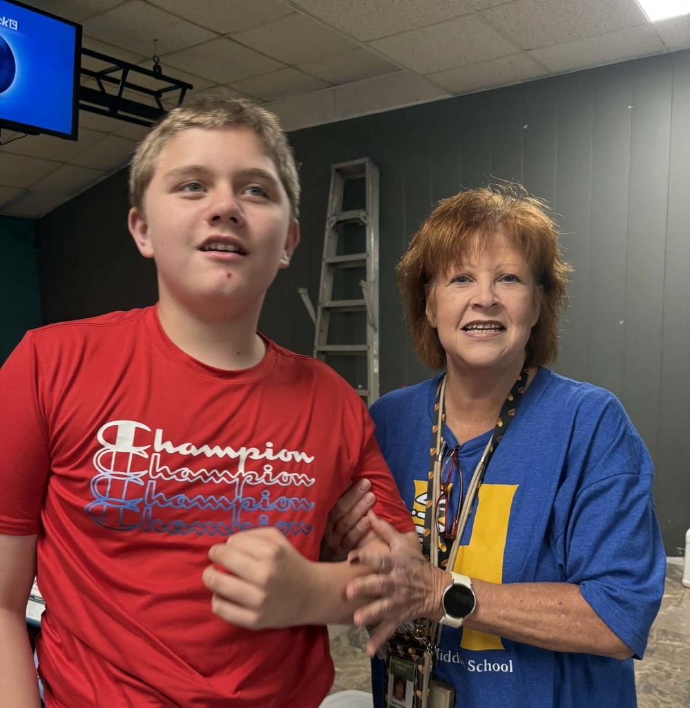 Student and teacher smiling on bowling trip