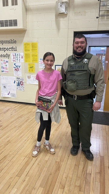 A student poses with a police officer for the picture.