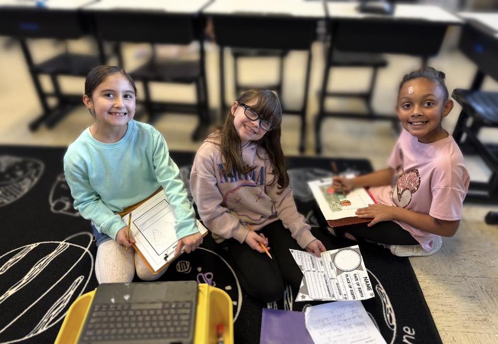 Southside Elementary School students are in the floor, on a carpet, doing research for Black History month.