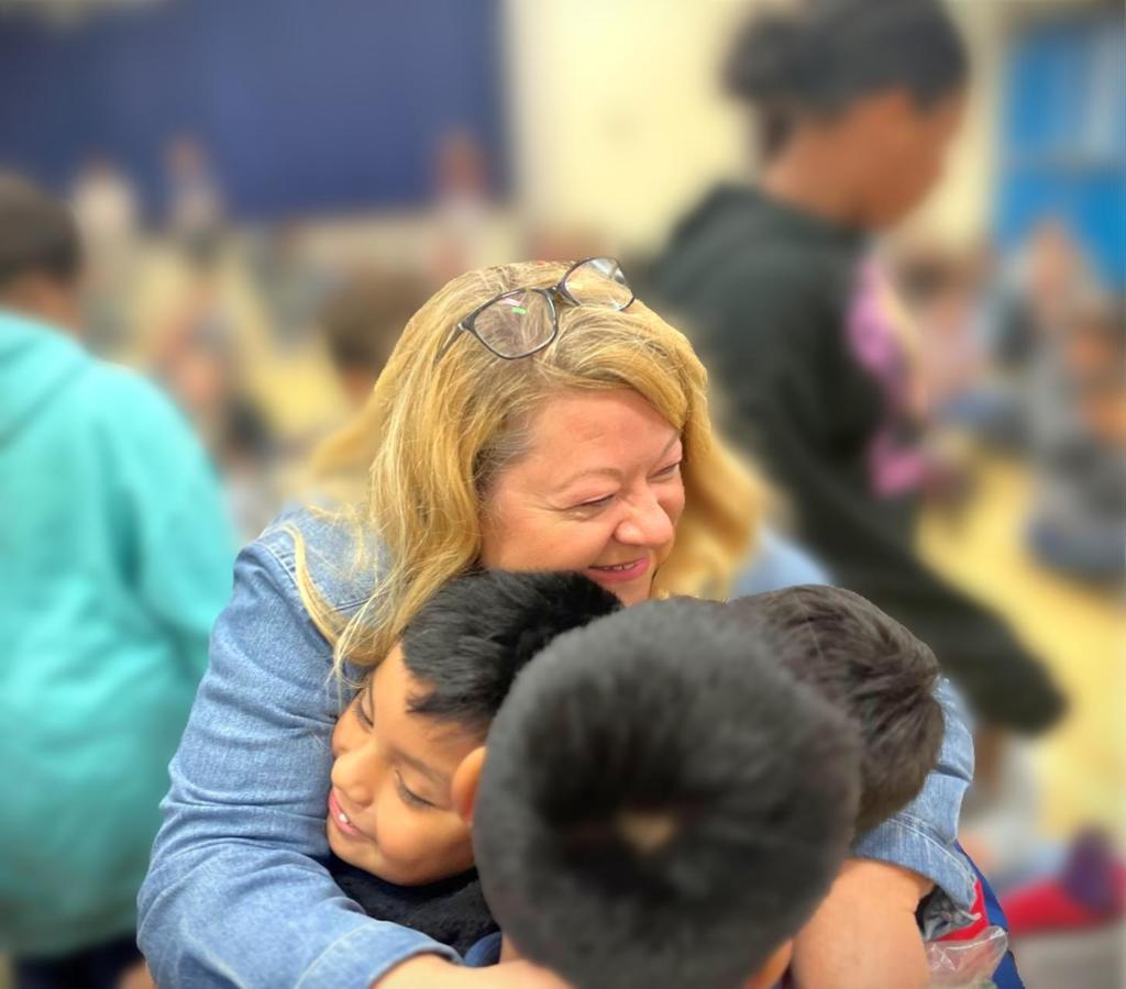 Eakin Elementary School teacher is hugging several students