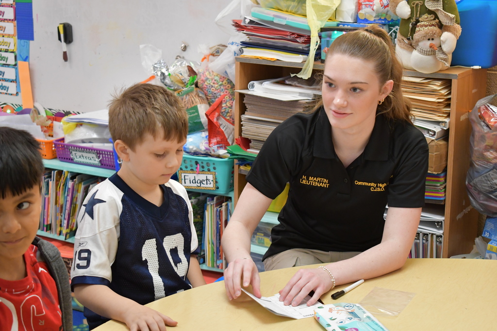 Community High School student is working with Community Elementary students conducting a Child I-Dent-A-Kit.