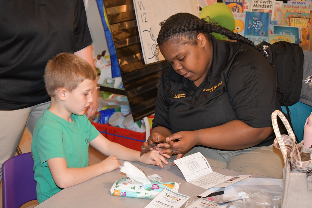 Community High School student is working with Community Elementary students conducting a Child I-Dent-A-Kit.