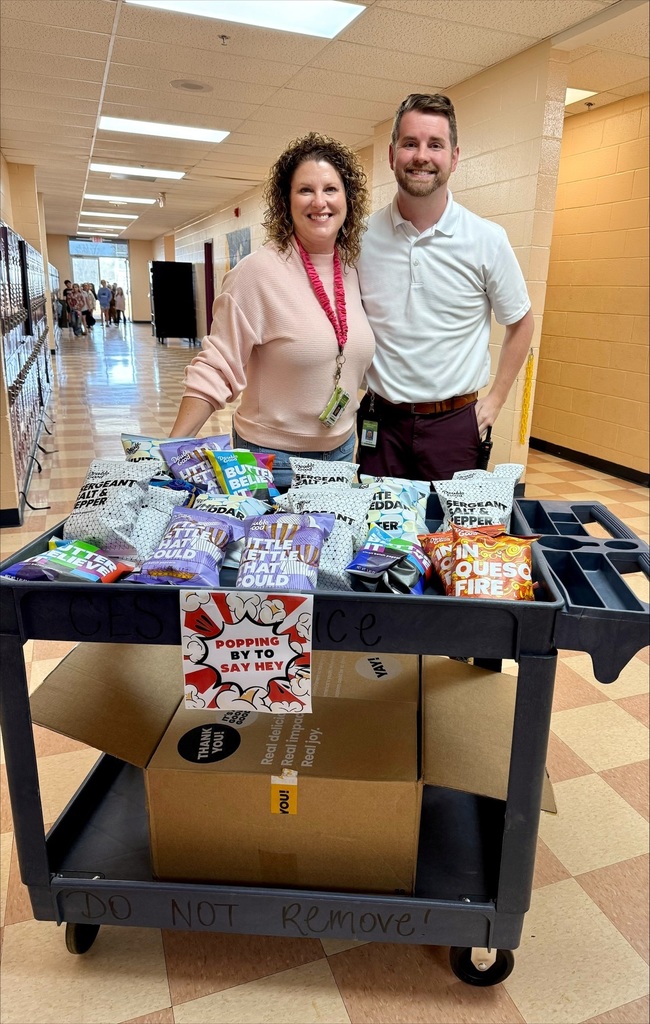 Community Elementary Admin Team is in the hallway with a cart containing popcorn to pass out to staff members. 