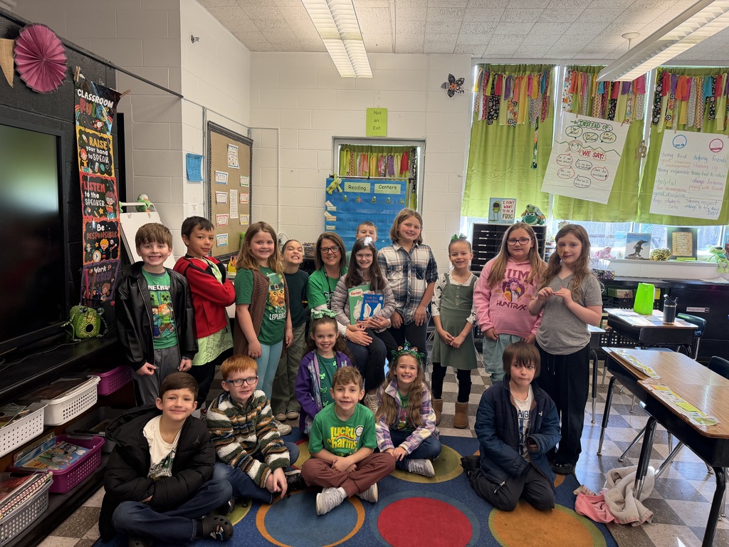 Guest reader poses with all the classroom's students for a group picture. 