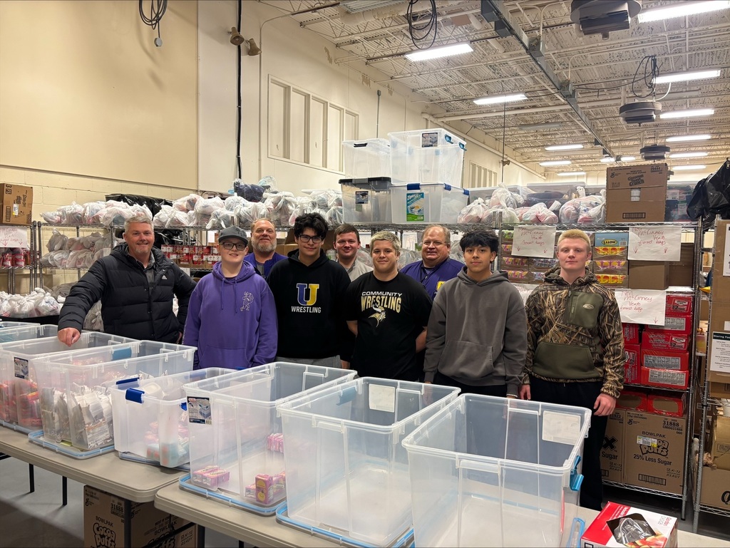 Community High School football players pack food bags for BCS backpack program. 