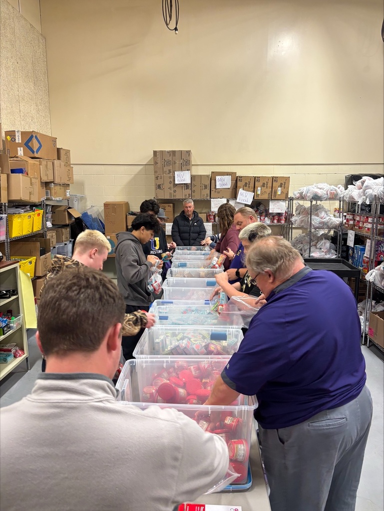 Community High School football players pack food bags for BCS backpack program. 