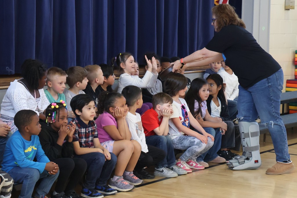 Students sitting during music performance with their Music teacher. 