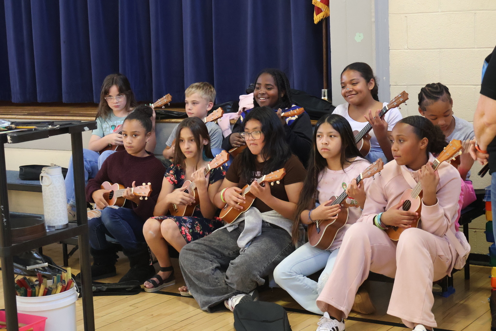A group of students playing ukeleles. 