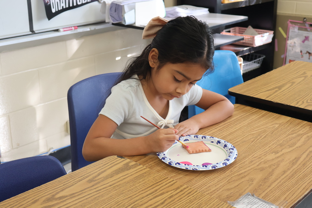Student painting her pottery piece. 