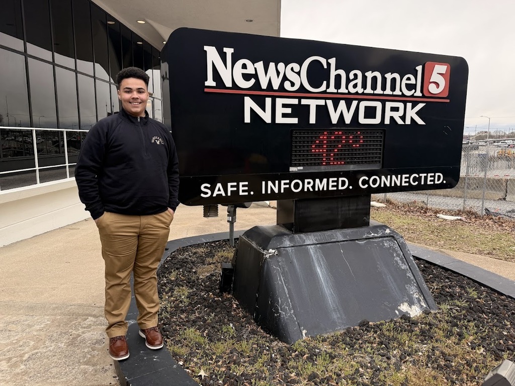 Student poses with News Channel 5 sign. 
