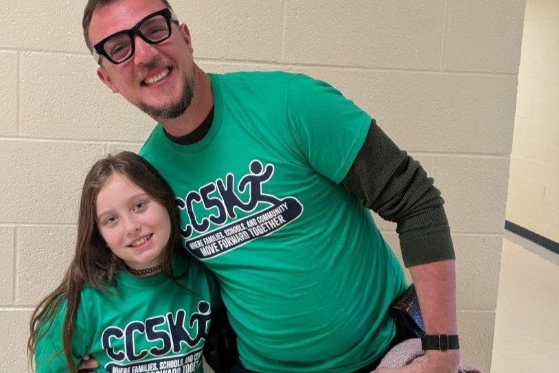 The Southside Elementary School SRO poses for a picture with a student and both are wearing their CC5K shirts. 