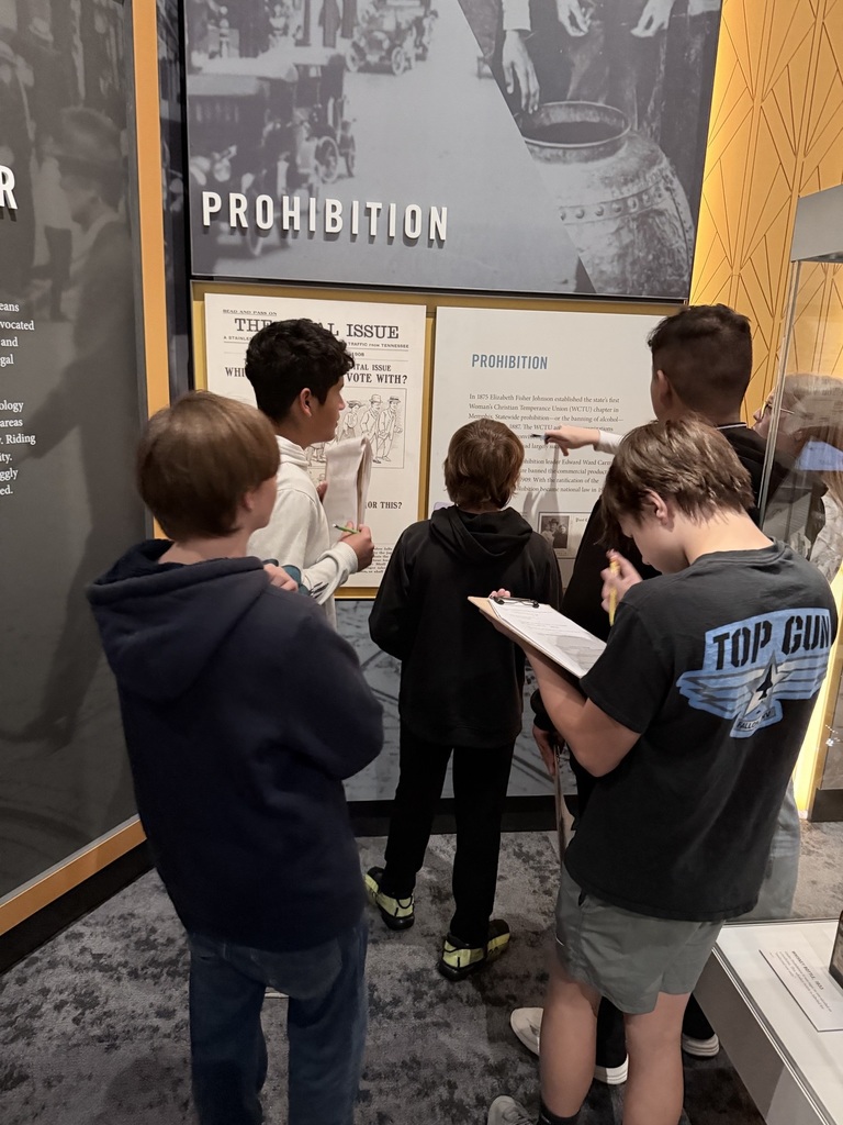 kids reading off a poster on a wall